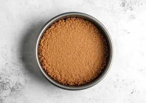 Graham cracker crust base for cheesecake in a springform pan